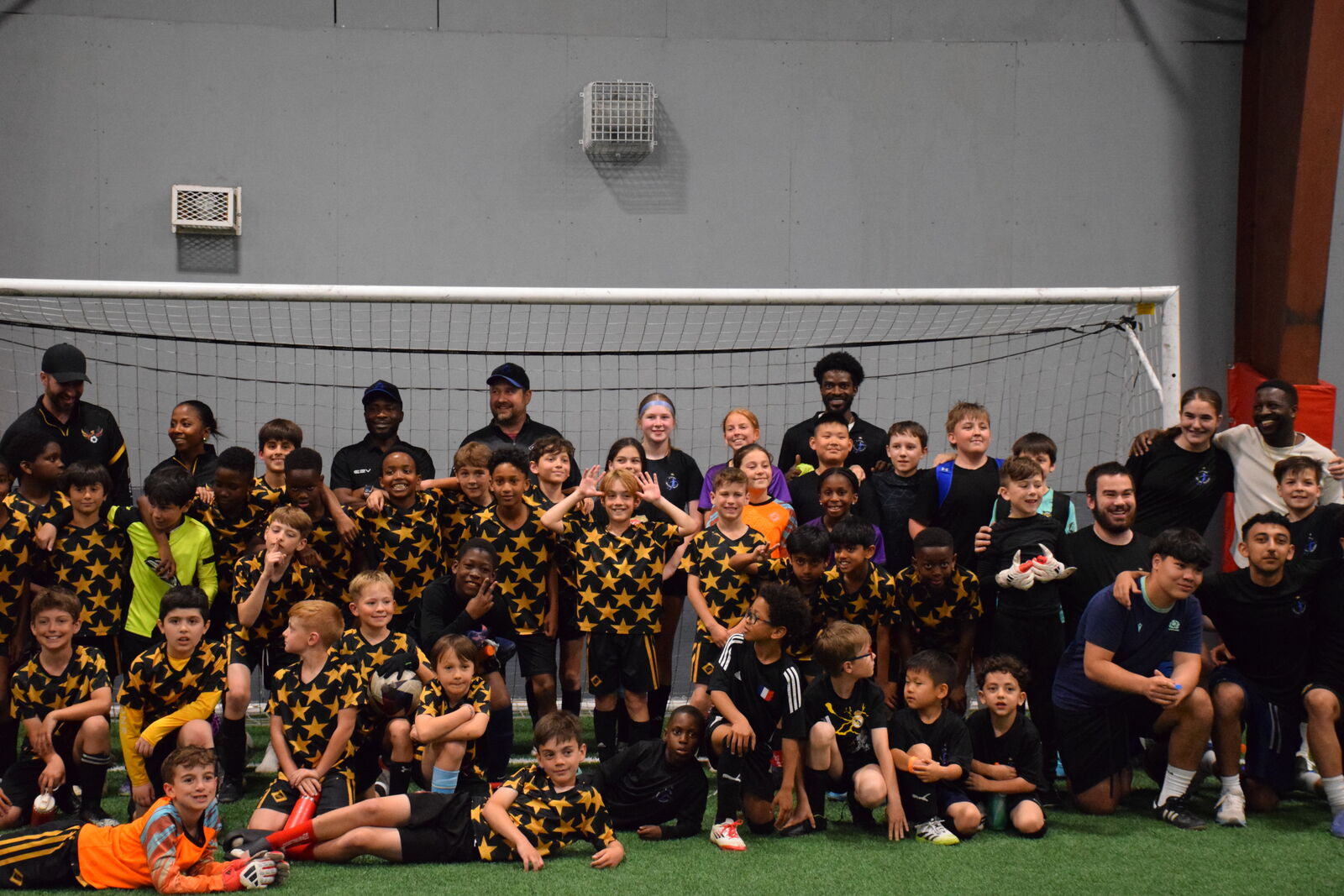 The full JStarz training community — players in the gold-star kit and coaches together at an indoor session in Halifax.